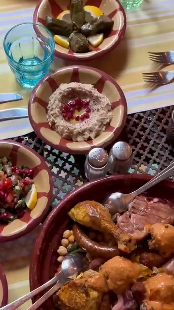 Une table dressée de mezzés, tajines et salades